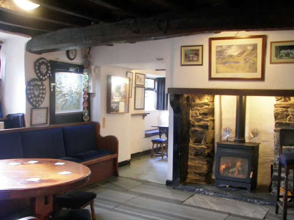 Inside the Newfield Inn: wood-burning stove, settle and framed pictures